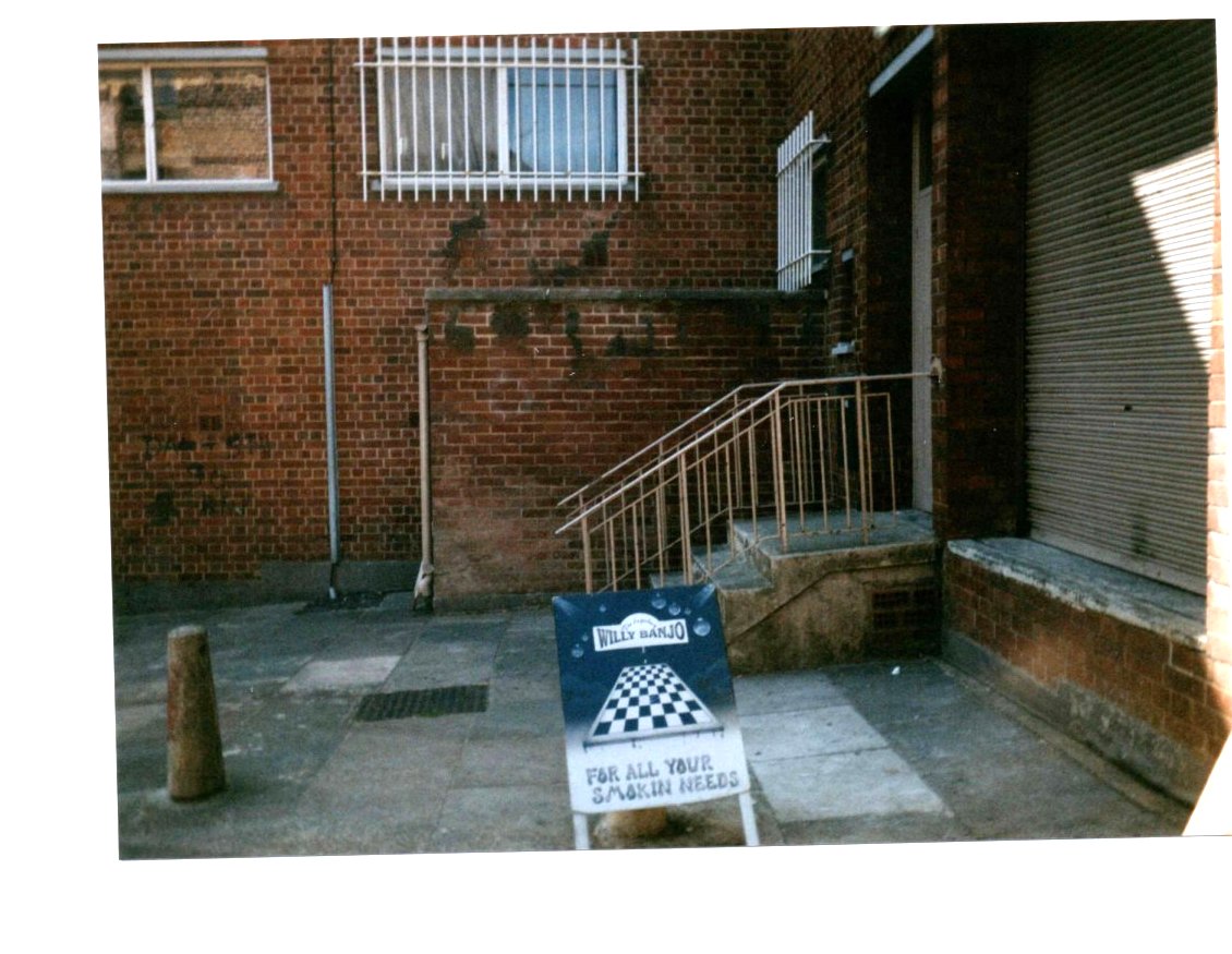 The alley approach to Willy Banjo with Andy Baron door art visible