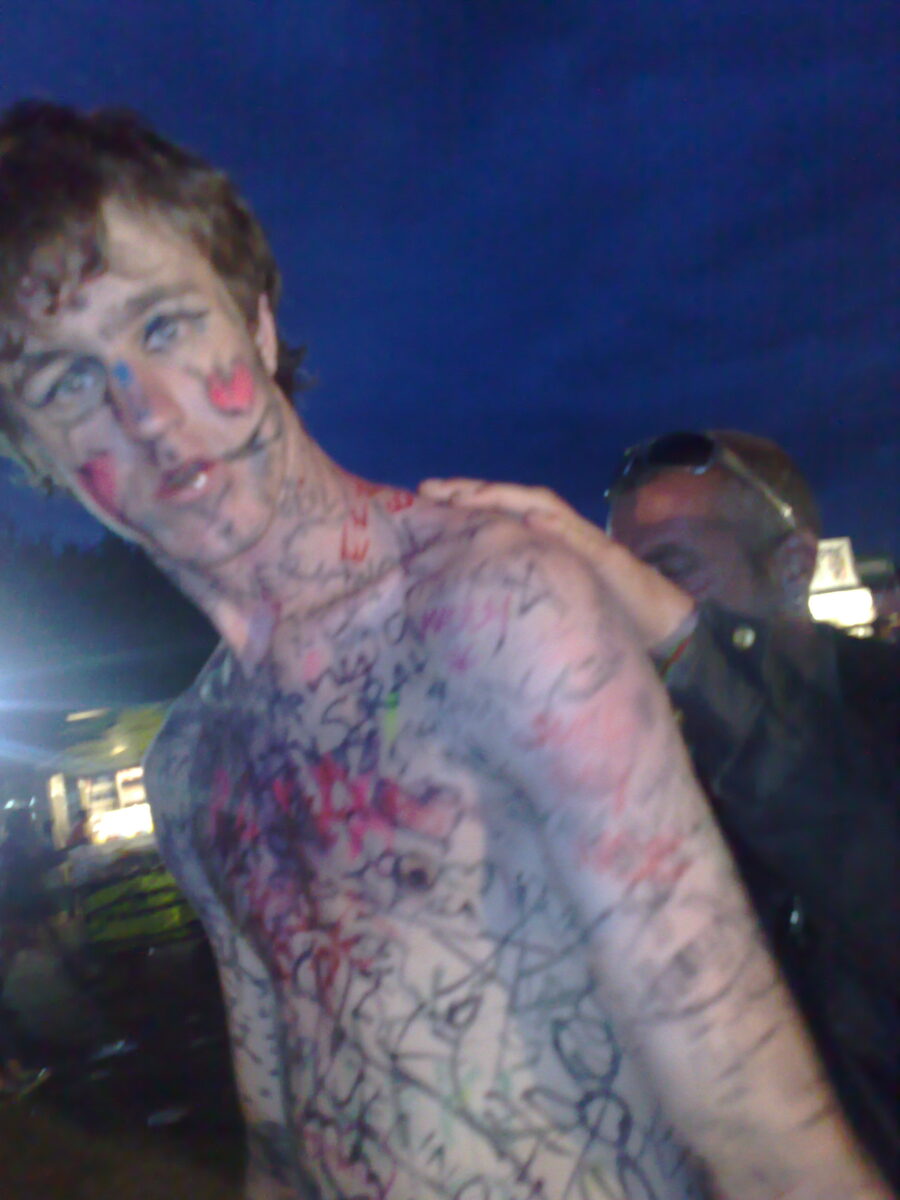 A festival-goer covered head to toe in marker pen signatures from the crew