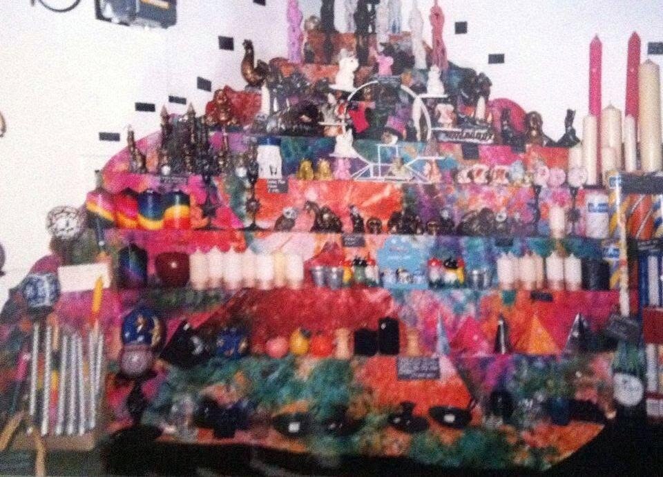 Willy Banjo candle display wall in the 1990s, packed shelves of candles and ornaments on tie-dye fabric
