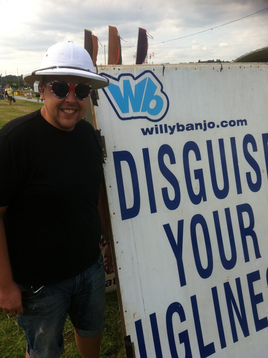 Willy Banjo crew at the stall, UV face paint sign behind them