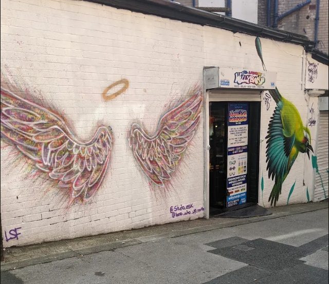 Angel wings by Studio Ask and a green bird by Meret One outside Willy Banjo